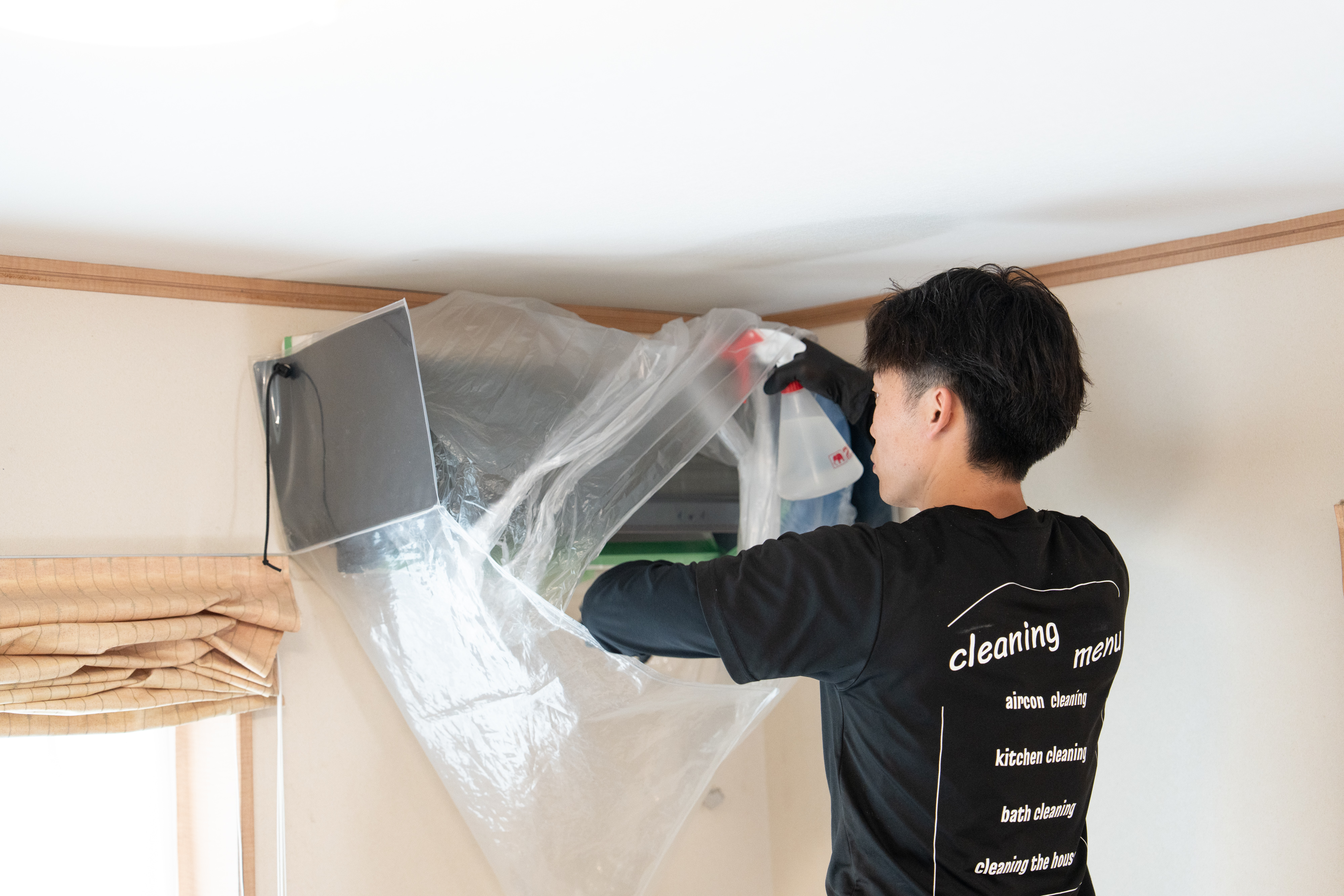 養生をして高圧洗浄を行うエアコンクリーニングの作業の様子
